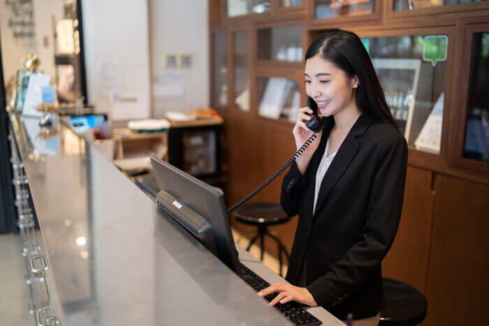 Receptionist at hotel front desk, using a computer with managed IT services