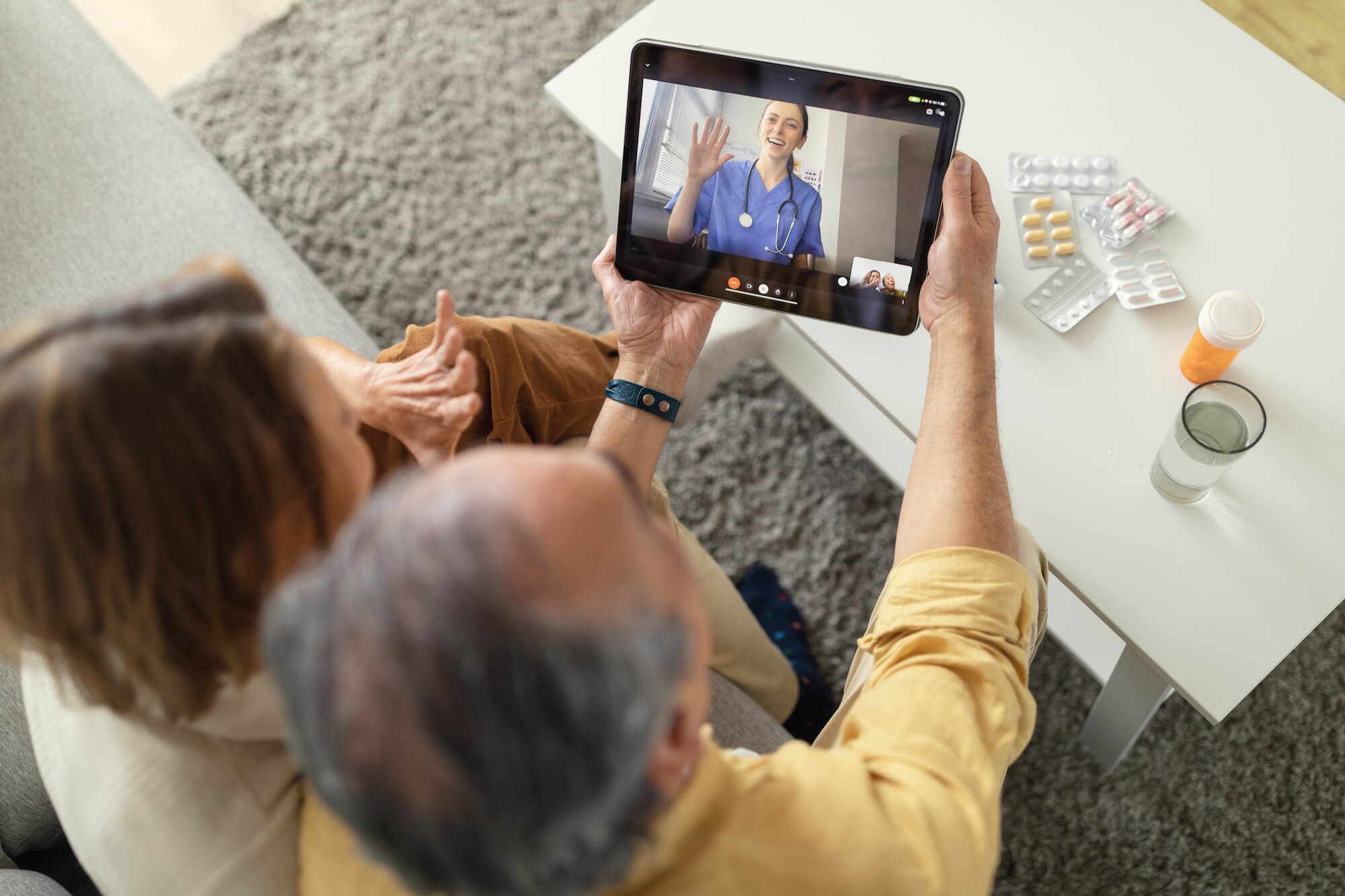 Senior couple using telemedicine services via their iPad to talk to a doctor